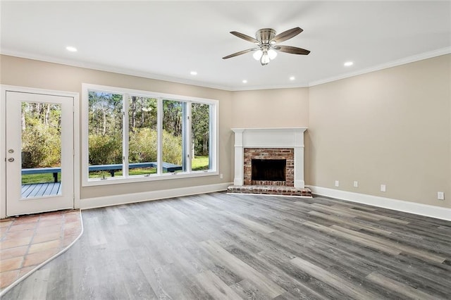 unfurnished living room with hardwood / wood-style flooring, crown molding, ceiling fan, and a fireplace