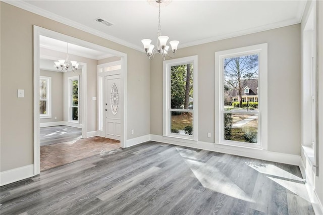 unfurnished dining area featuring hardwood / wood-style floors, ornamental molding, and a chandelier