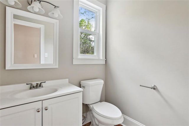 bathroom with vanity, toilet, and a healthy amount of sunlight