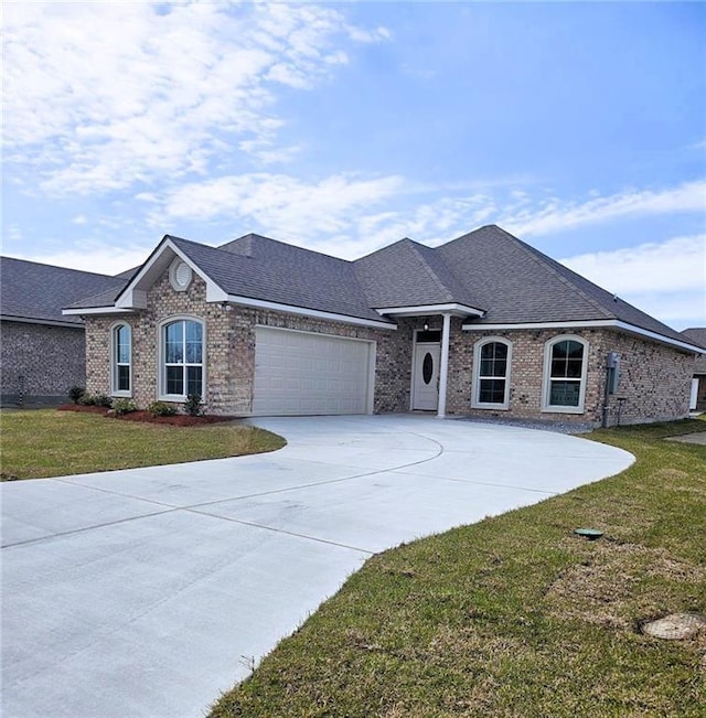 single story home featuring roof with shingles, brick siding, a garage, driveway, and a front lawn