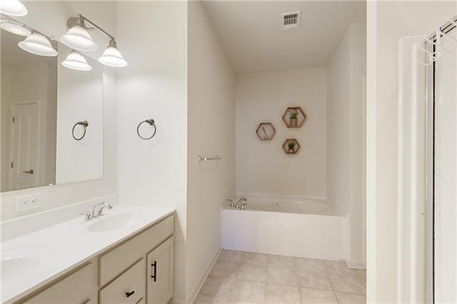 full bathroom with a bathing tub, a sink, visible vents, tile patterned floors, and double vanity