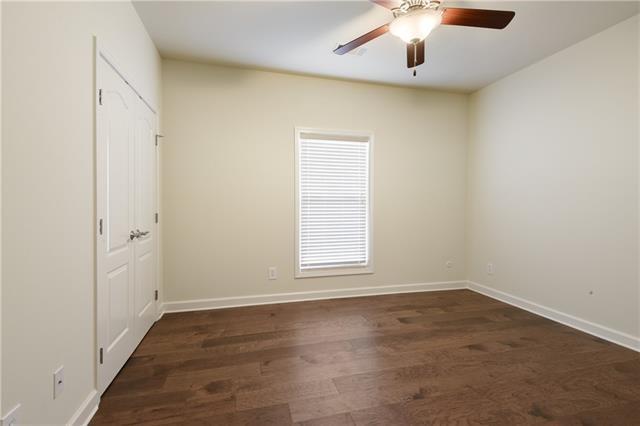 unfurnished room featuring ceiling fan, dark wood-type flooring, and baseboards