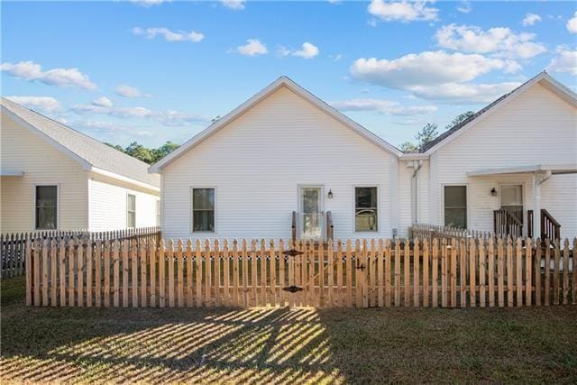 back of property featuring a yard and a fenced front yard