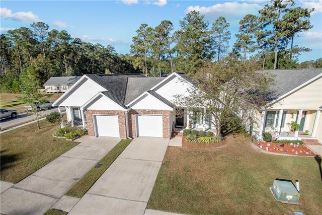 view of front of home featuring a front yard, brick siding, driveway, and an attached garage