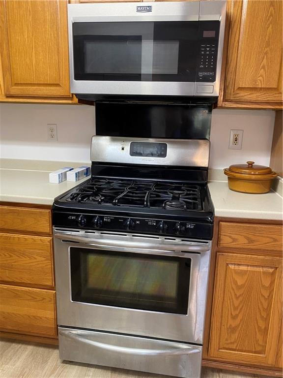 kitchen with appliances with stainless steel finishes and light hardwood / wood-style flooring