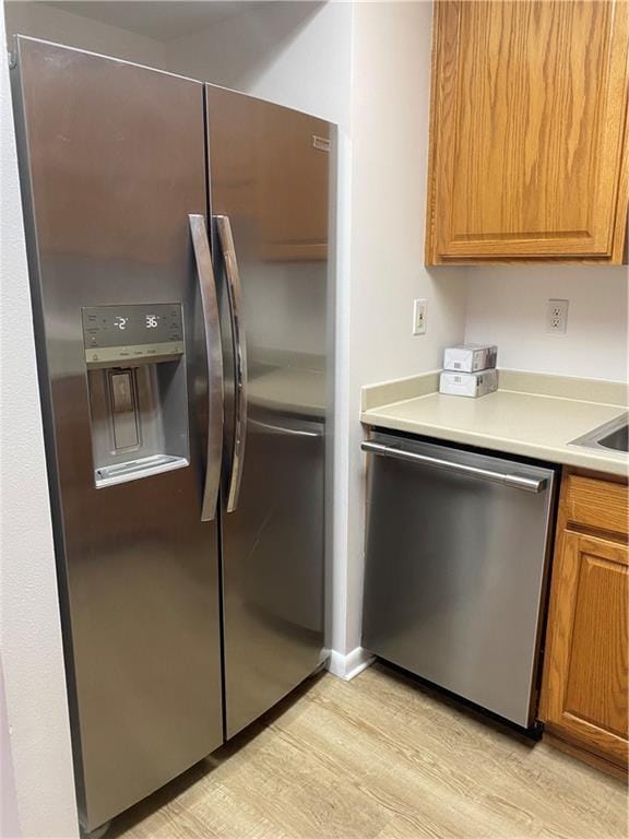 kitchen featuring appliances with stainless steel finishes and light hardwood / wood-style floors