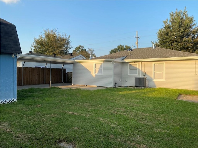 back of property with central AC, a yard, and a patio area