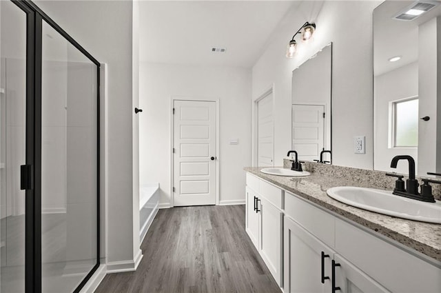 bathroom with vanity, hardwood / wood-style floors, and separate shower and tub