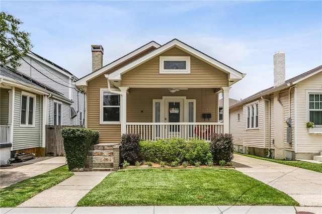 bungalow-style home featuring covered porch and a front yard