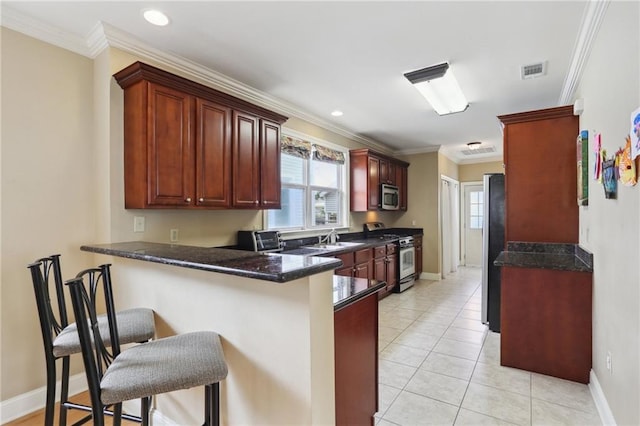 kitchen with ornamental molding, stainless steel appliances, and kitchen peninsula