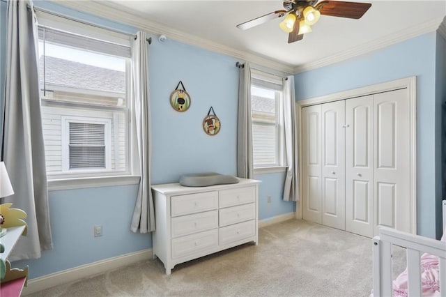 carpeted bedroom featuring ornamental molding, ceiling fan, and a closet