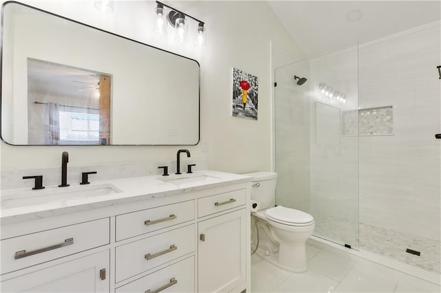 bathroom with tiled shower, vanity, toilet, and tile patterned flooring