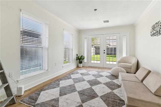 interior space with french doors, crown molding, and hardwood / wood-style floors