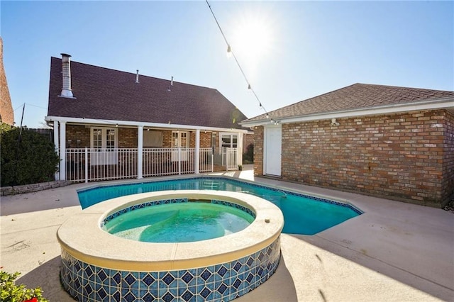 view of swimming pool featuring a patio area and an in ground hot tub