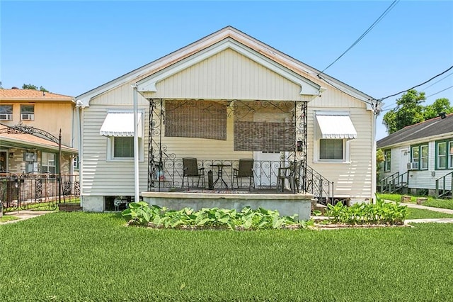 rear view of property featuring a yard and covered porch