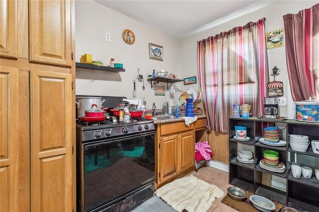 kitchen with light tile patterned floors and black gas range oven