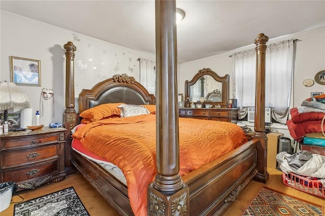 bedroom with decorative columns and light wood-type flooring