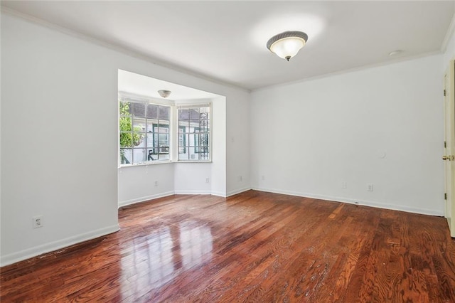 spare room with crown molding and dark wood-type flooring