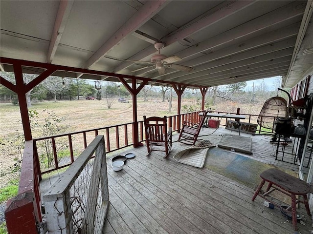 wooden deck with ceiling fan and a yard