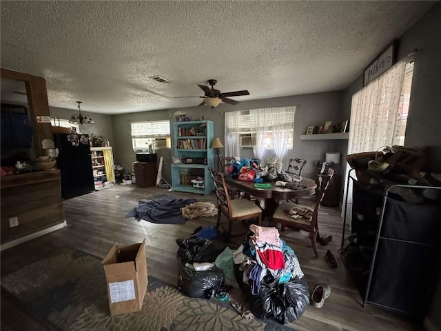 miscellaneous room featuring wood-type flooring, ceiling fan with notable chandelier, and a textured ceiling