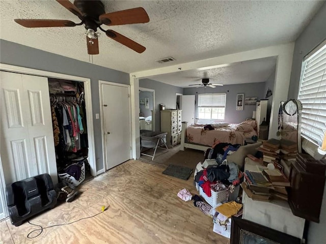 bedroom featuring ceiling fan, a closet, and a textured ceiling