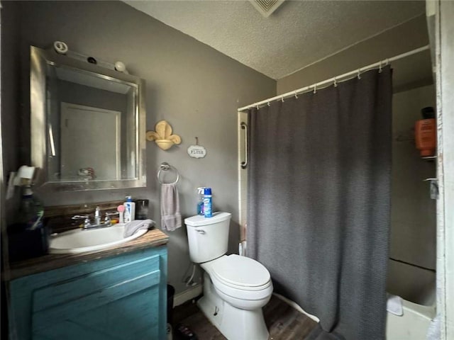 full bathroom featuring hardwood / wood-style flooring, shower / bath combo, vanity, a textured ceiling, and toilet