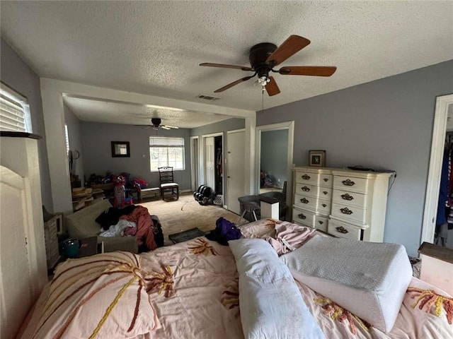 carpeted bedroom with a textured ceiling and ceiling fan