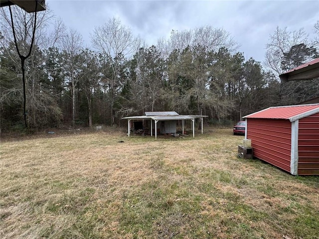 view of yard featuring a carport and an outdoor structure