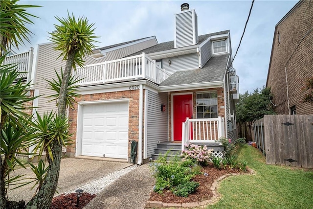 view of front of home featuring a garage, a balcony, and a front yard