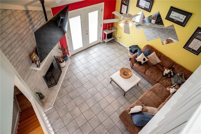 tiled living room with french doors and ceiling fan