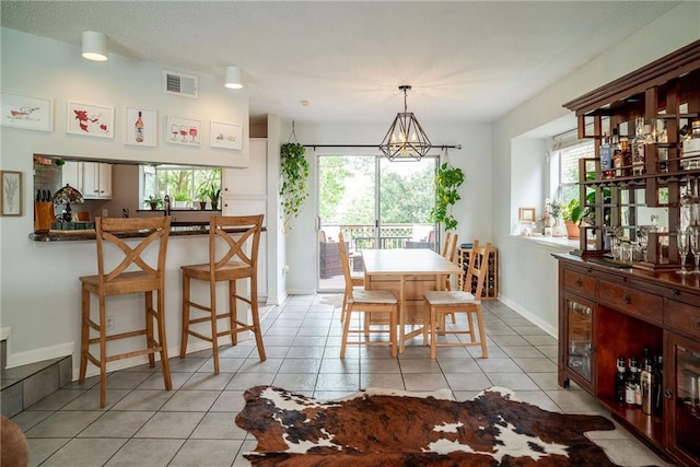 dining space with an inviting chandelier and light tile patterned floors