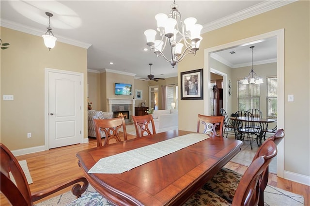 dining room featuring crown molding, light hardwood / wood-style flooring, and ceiling fan with notable chandelier