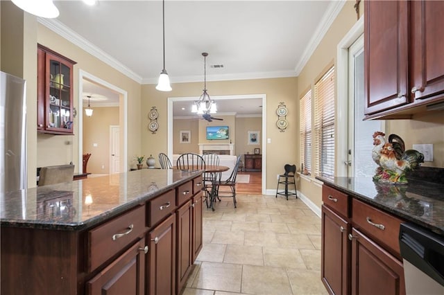 kitchen featuring dishwasher, dark stone countertops, a center island, ornamental molding, and decorative light fixtures