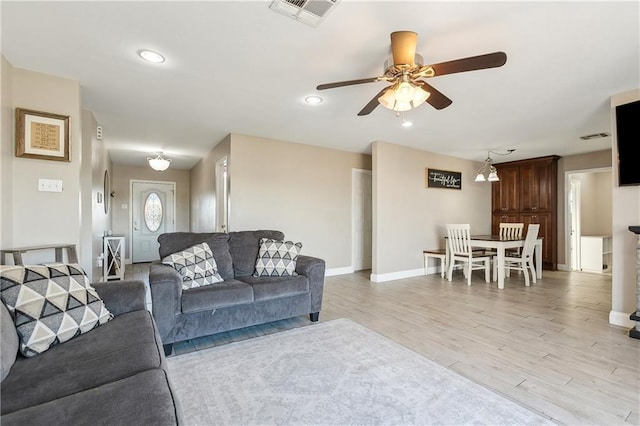 living room featuring light hardwood / wood-style flooring and ceiling fan