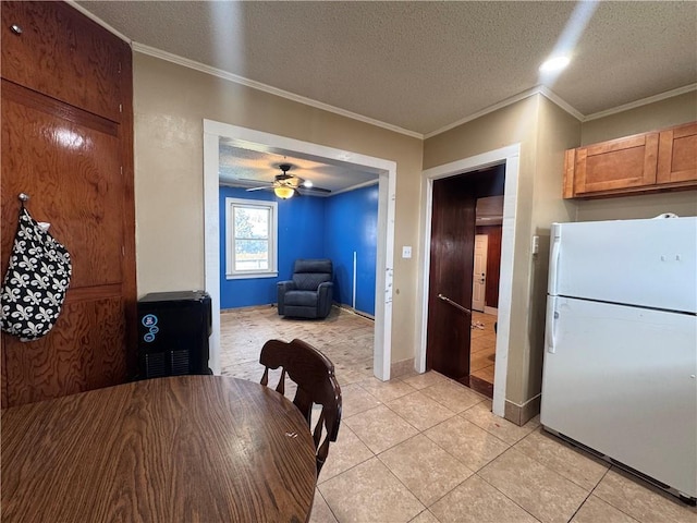 dining area with crown molding, light tile patterned floors, ceiling fan, and a textured ceiling