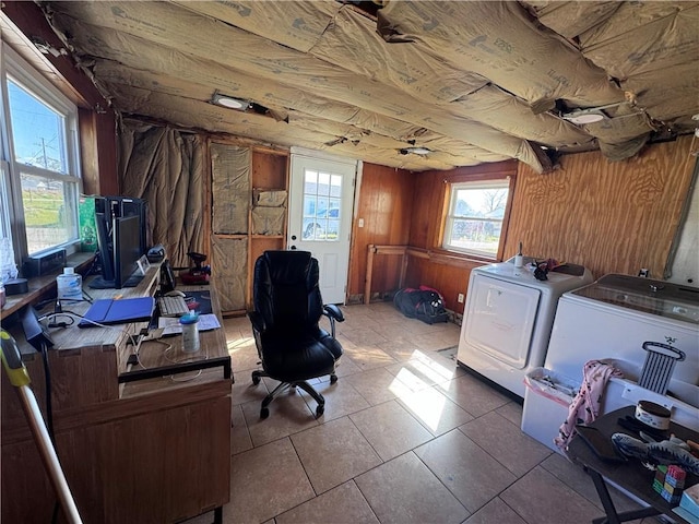 office area with tile patterned floors, wooden walls, and washer and dryer