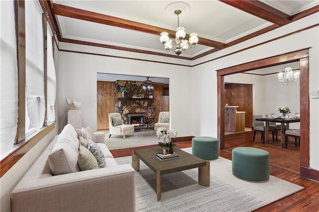 living room with crown molding, dark wood-type flooring, beam ceiling, a notable chandelier, and a fireplace