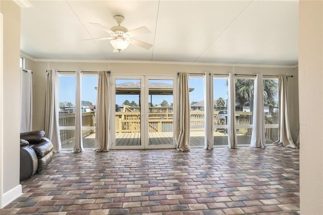 unfurnished sunroom with ceiling fan