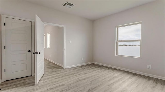 empty room with light hardwood / wood-style flooring