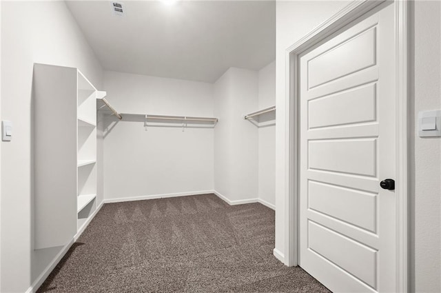 walk in closet featuring dark carpet