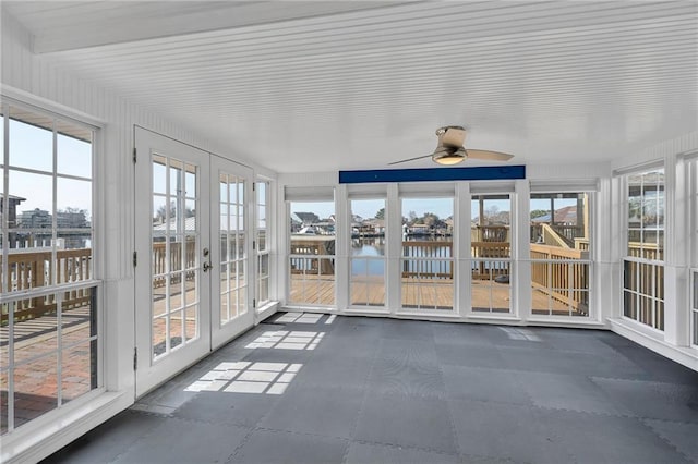 unfurnished sunroom featuring a water view and french doors