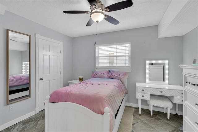 bedroom featuring ceiling fan and a textured ceiling