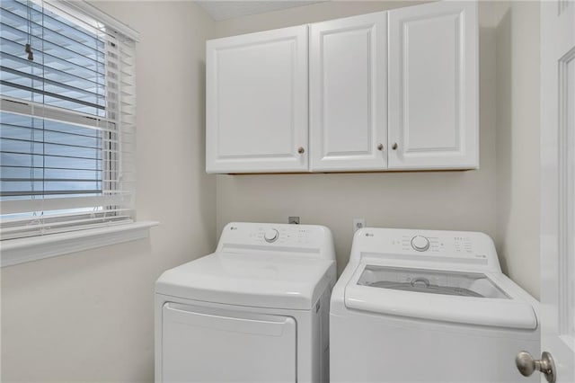 washroom featuring washing machine and dryer and cabinets