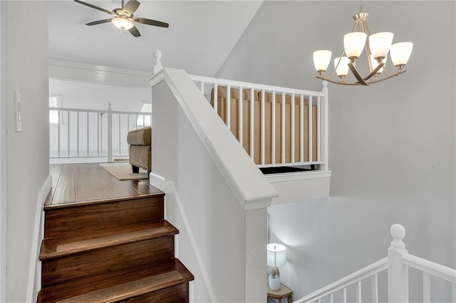 staircase with ceiling fan with notable chandelier