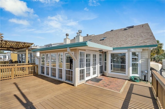 back of house featuring a wooden deck, a pergola, a sunroom, and french doors