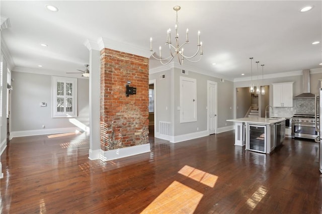 kitchen with decorative light fixtures, tasteful backsplash, an island with sink, wine cooler, and high end stainless steel range