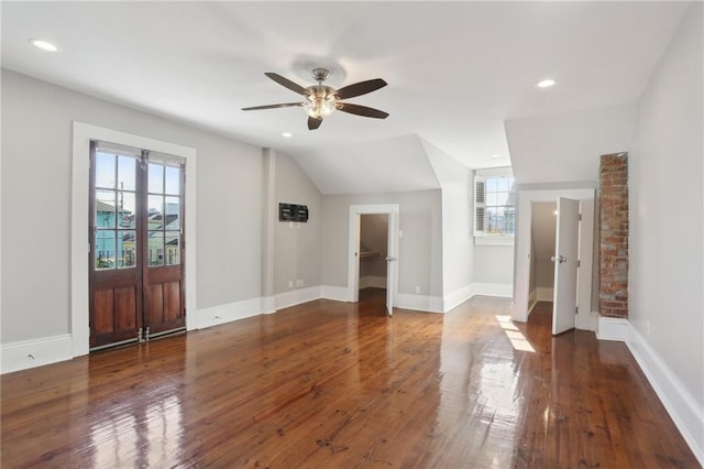 interior space with ceiling fan, lofted ceiling, and dark hardwood / wood-style flooring