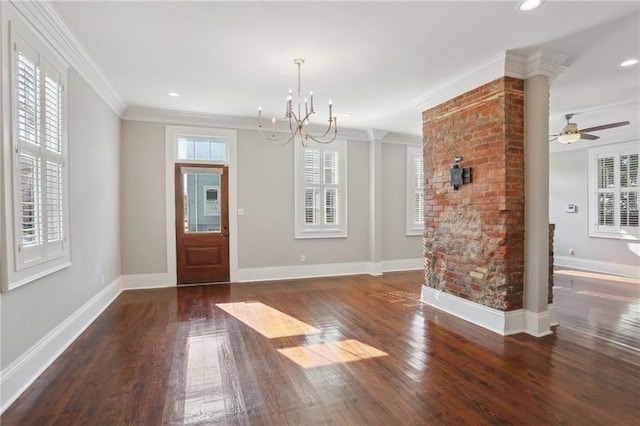 foyer with ornate columns, crown molding, dark wood-type flooring, and ceiling fan with notable chandelier