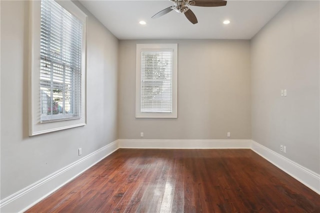 spare room featuring dark wood-type flooring and ceiling fan