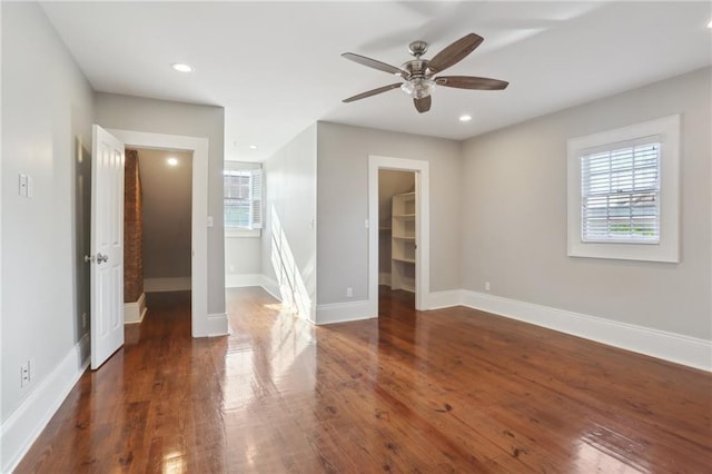 empty room with dark wood-type flooring and ceiling fan